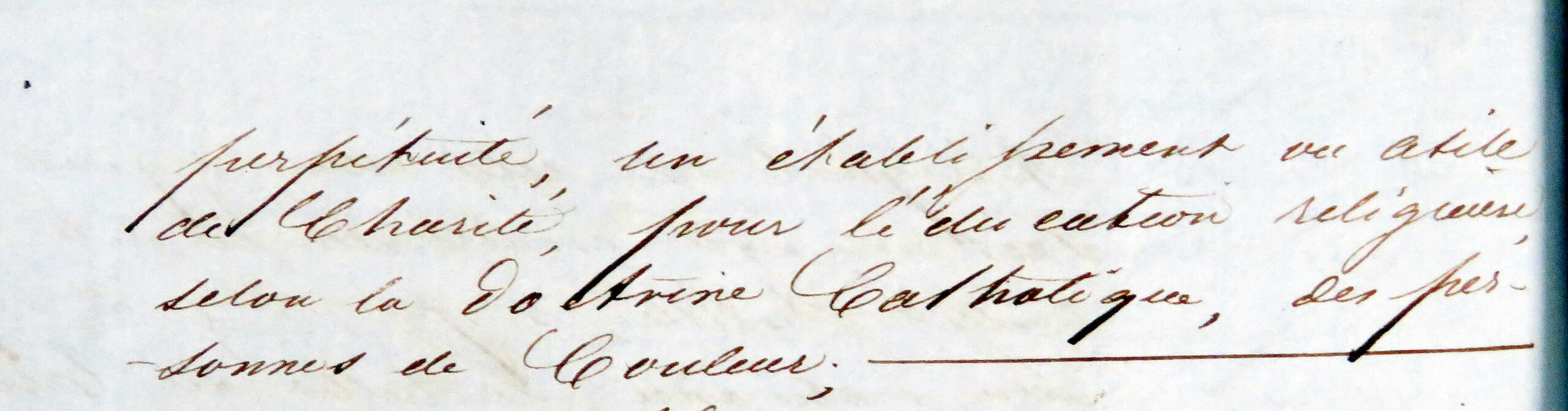 A close-up of handwritten French text from the 1850 deed stating the property was to be an establishment of charity for the religious education of people of color, in perpetuity.